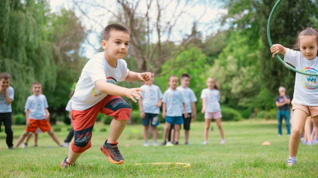 A group of children actively playing with hula hoops on a bright summer day in the park.